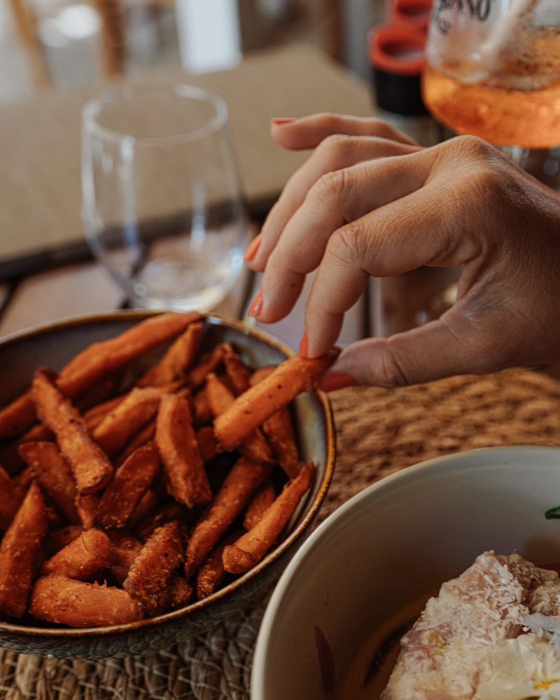Frites de patate douce dorées servies avec un spritz