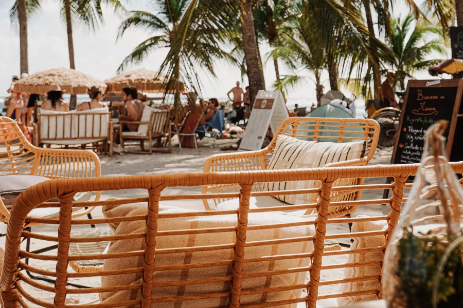 Terrasse en rotin du Manaïa sous les cocotiers, face à la plage de Sainte-Anne